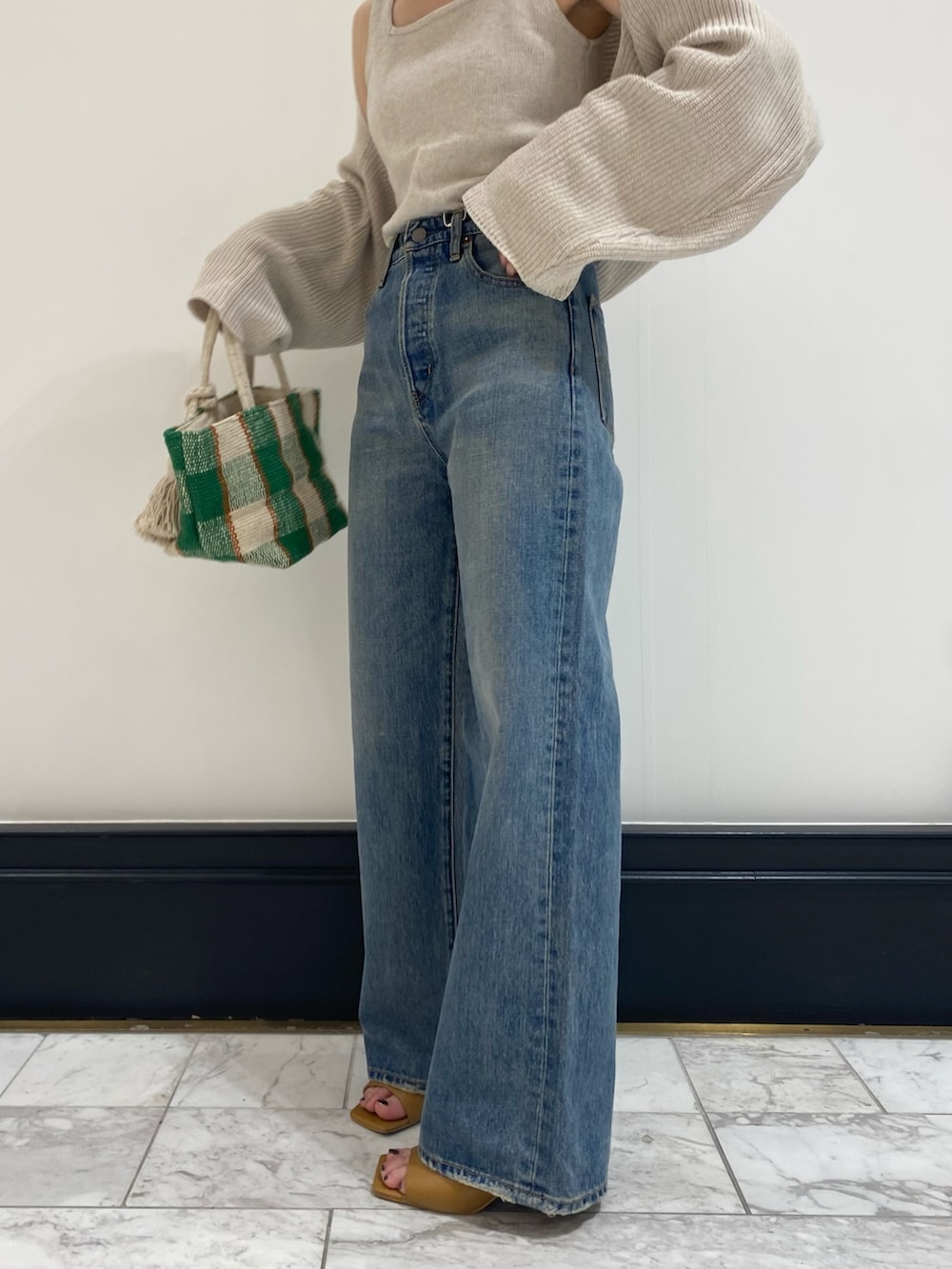 ブルー系のデニムパンツ、ホワイト系のニット/セーターを着用したレディースの春コーディネートの2枚目の写真