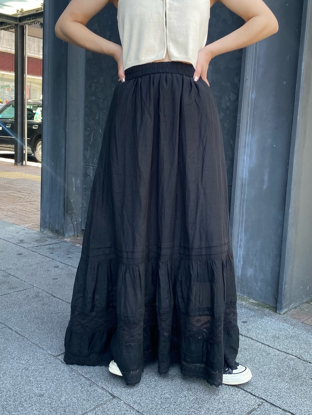 ホワイト系のベスト、ブラック系のスカートを着用したレディースの夏コーディネートの5枚目の写真