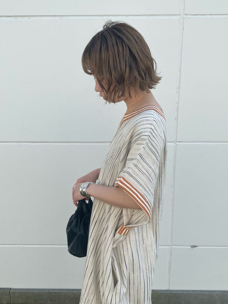 オレンジ系のその他パンツ、オレンジ系のワンピース、ブラック系のハンドバッグを着用したレディースの春コーディネートの2枚目の写真