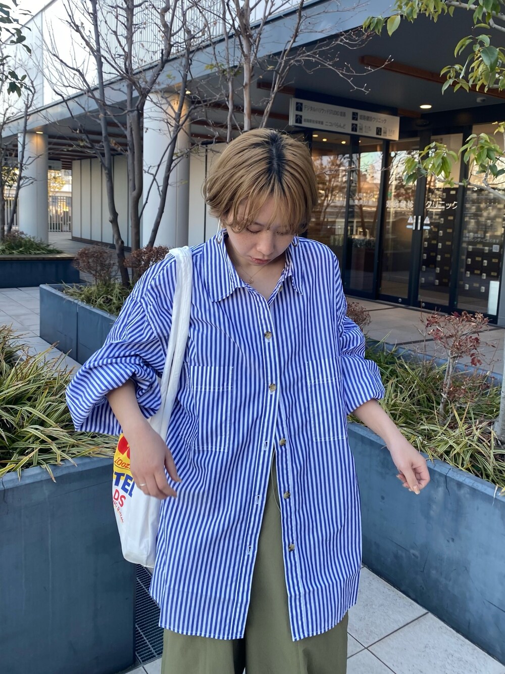 ブルー系のシャツ/ブラウス、グリーン系のカーゴパンツ、ホワイト系のエコバッグ/サブバッグを着用したレディースの冬コーディネートの7枚目の写真