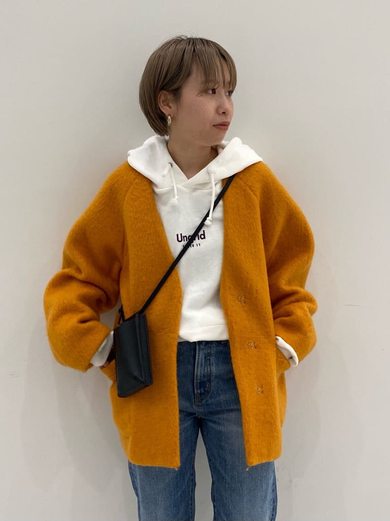 ブルー系のデニムパンツ、イエロー系のテーラードジャケット、ホワイト系のパーカーを着用したレディースの秋コーディネートの2枚目の写真