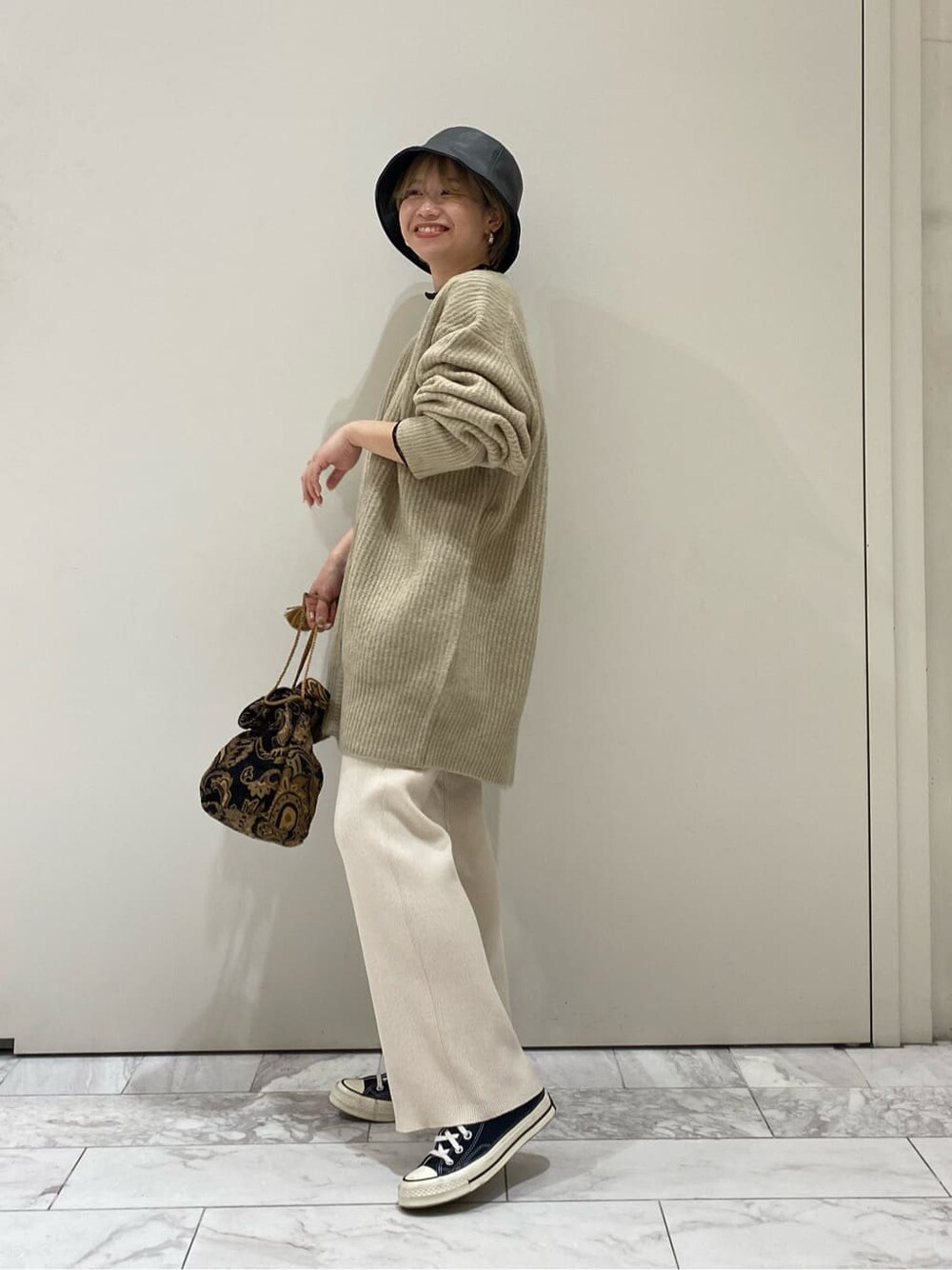 ブラック系のハンドバッグ、ブラック系のTシャツ/カットソー、ホワイト系のその他パンツを着用したレディースの秋コーディネートの2枚目の写真