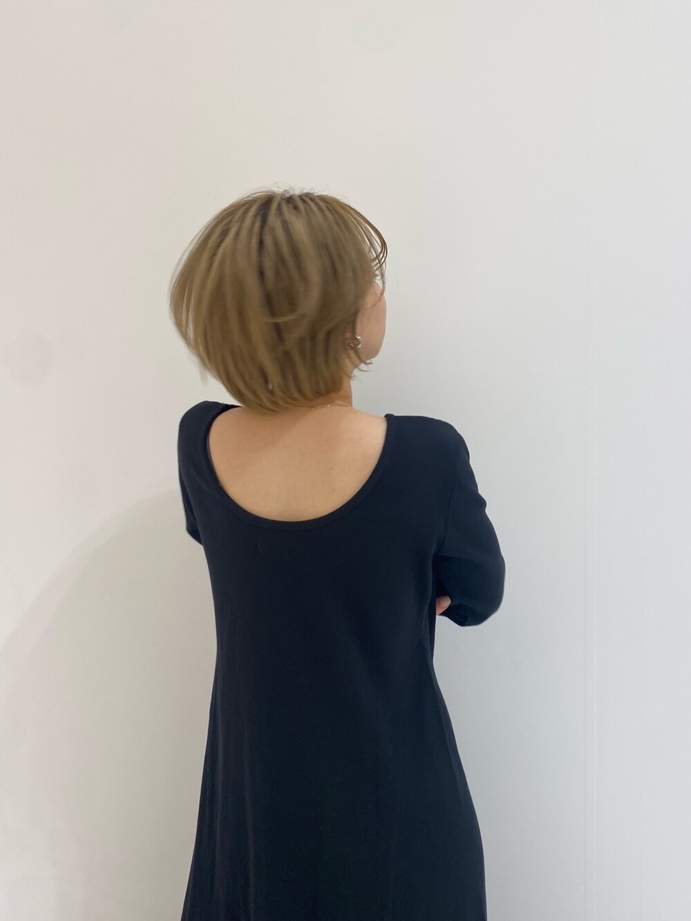 ベージュ系のステンカラーコートを着用したレディースの春コーディネートの6枚目の写真