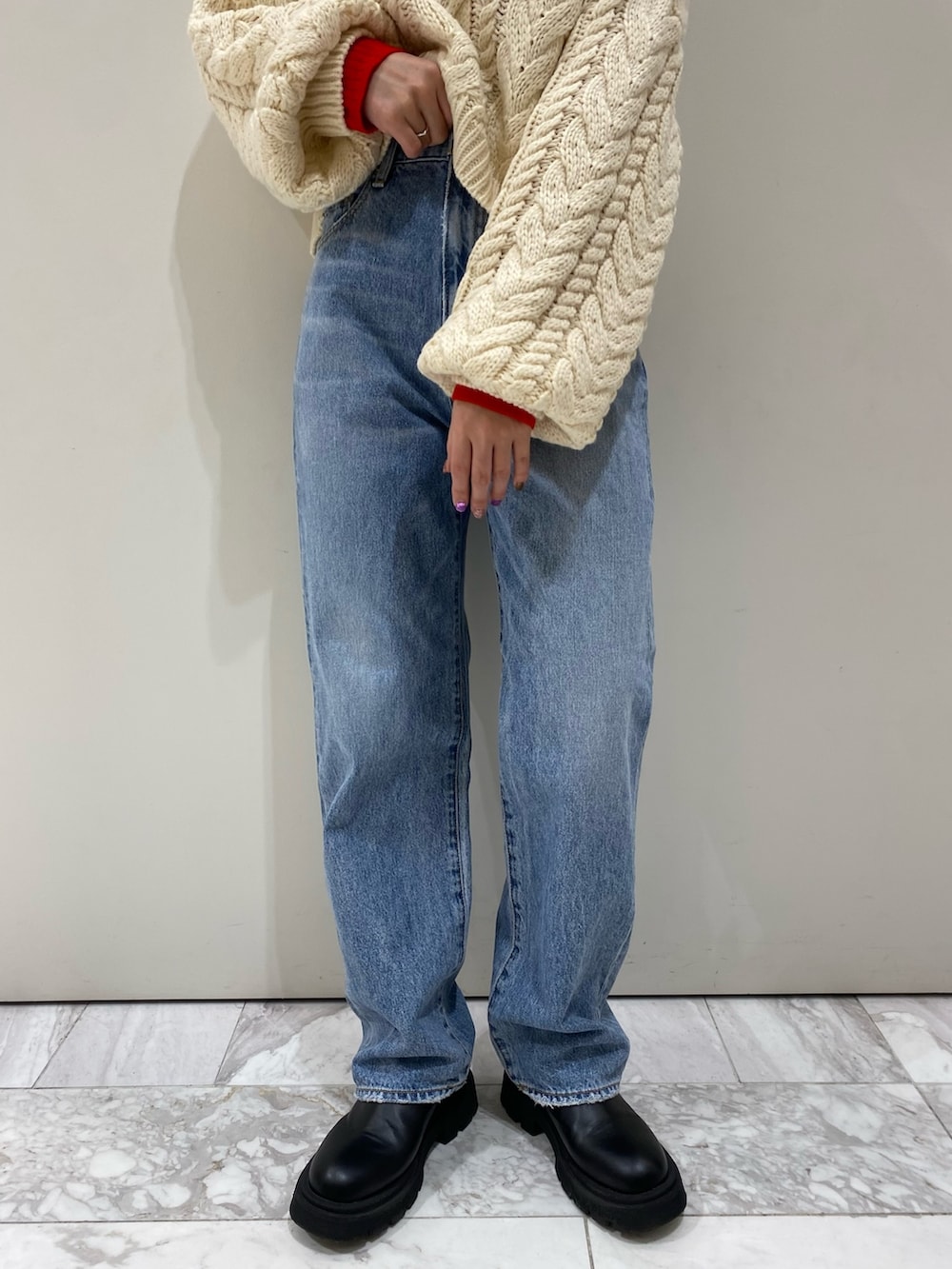 ブルー系のデニムパンツ、ホワイト系のニット/セーター、レッド系のニット/セーターを着用したレディースの冬コーディネートの3枚目の写真