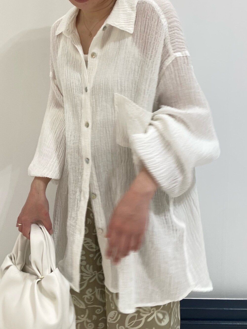 ブラック系のパンプス、ホワイト系のシャツ/ブラウス、ブラック系のハンドバッグを着用したレディースの春コーディネートの4枚目の写真