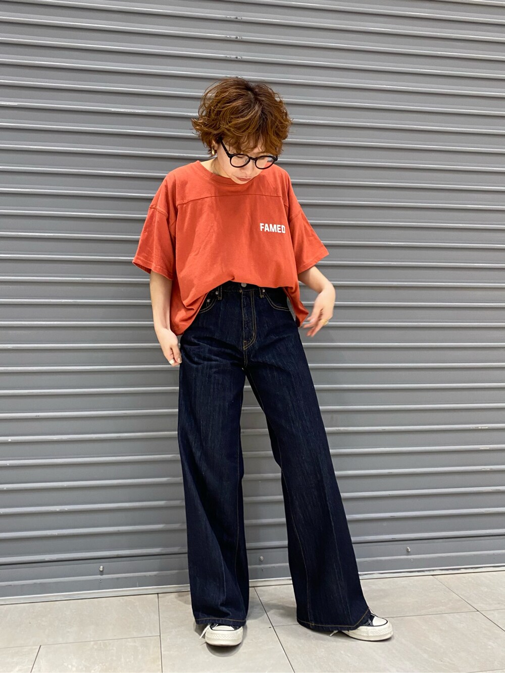 ブルー系のデニムパンツ、オレンジ系のTシャツ/カットソーを着用したレディースの春コーディネートの4枚目の写真