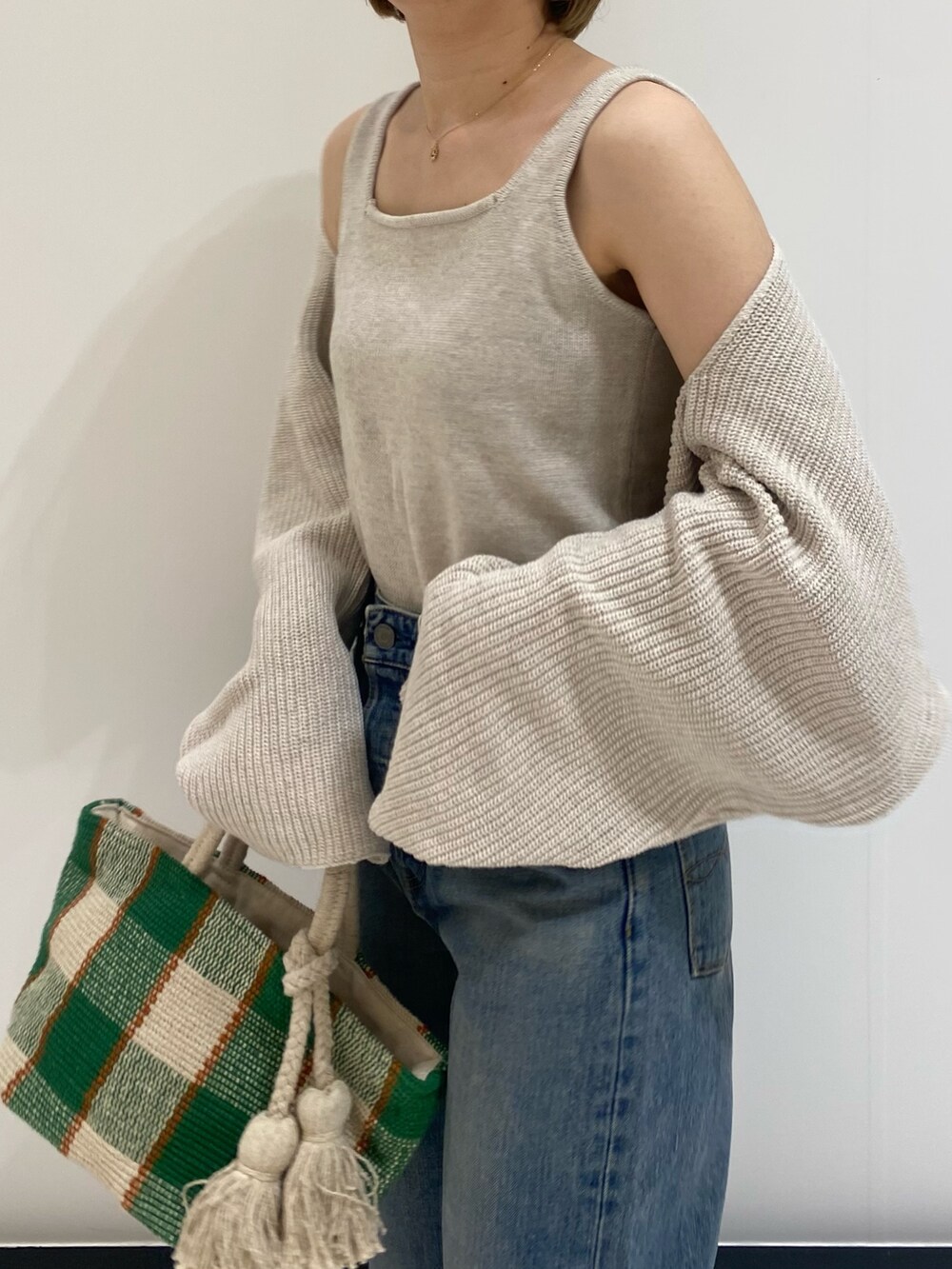 ブルー系のデニムパンツ、ホワイト系のニット/セーターを着用したレディースの春コーディネートの8枚目の写真