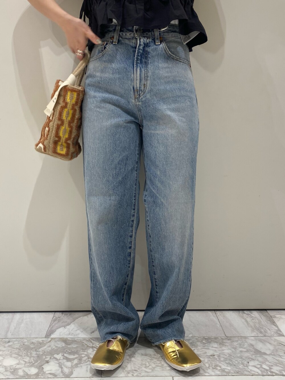 ブラック系のワンピース、ホワイト系のTシャツ/カットソー、ゴールド系のパンプスを着用したレディースの春コーディネートの6枚目の写真