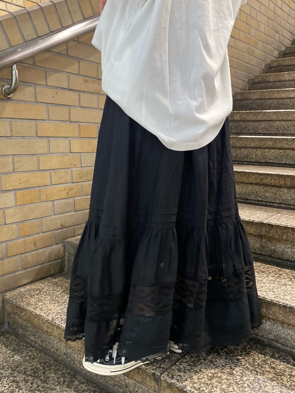 ブラック系のスカート、ホワイト系のTシャツ/カットソーを着用したレディースの夏コーディネートの7枚目の写真