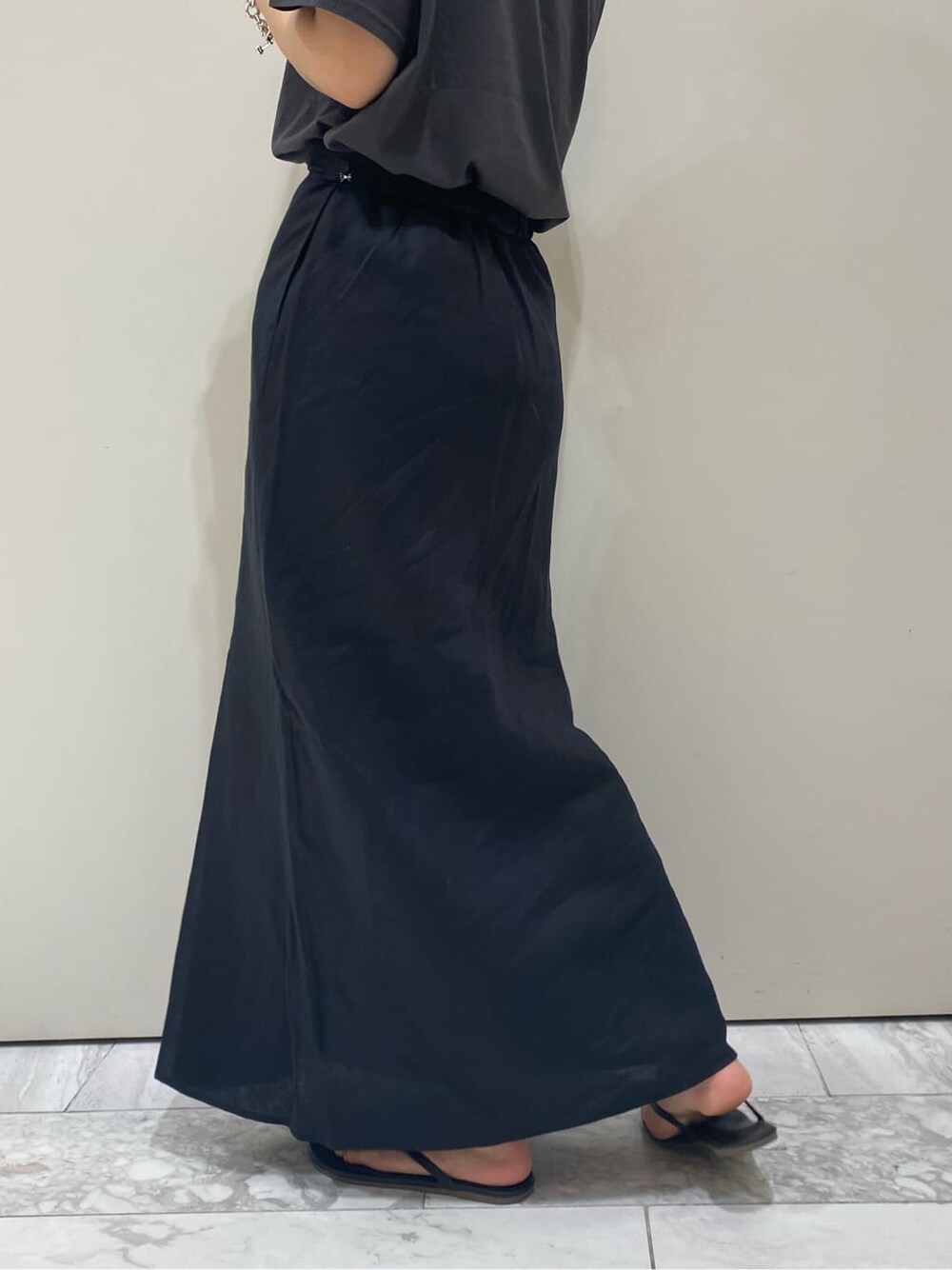 ブラック系のスカート、グレー系のTシャツ/カットソーを着用したレディースの夏コーディネートの4枚目の写真