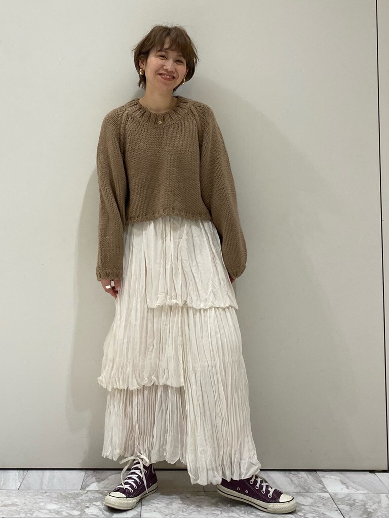 ホワイト系のスカート、ベージュ系のニット/セーターを着用したレディースの冬コーディネートの2枚目の写真