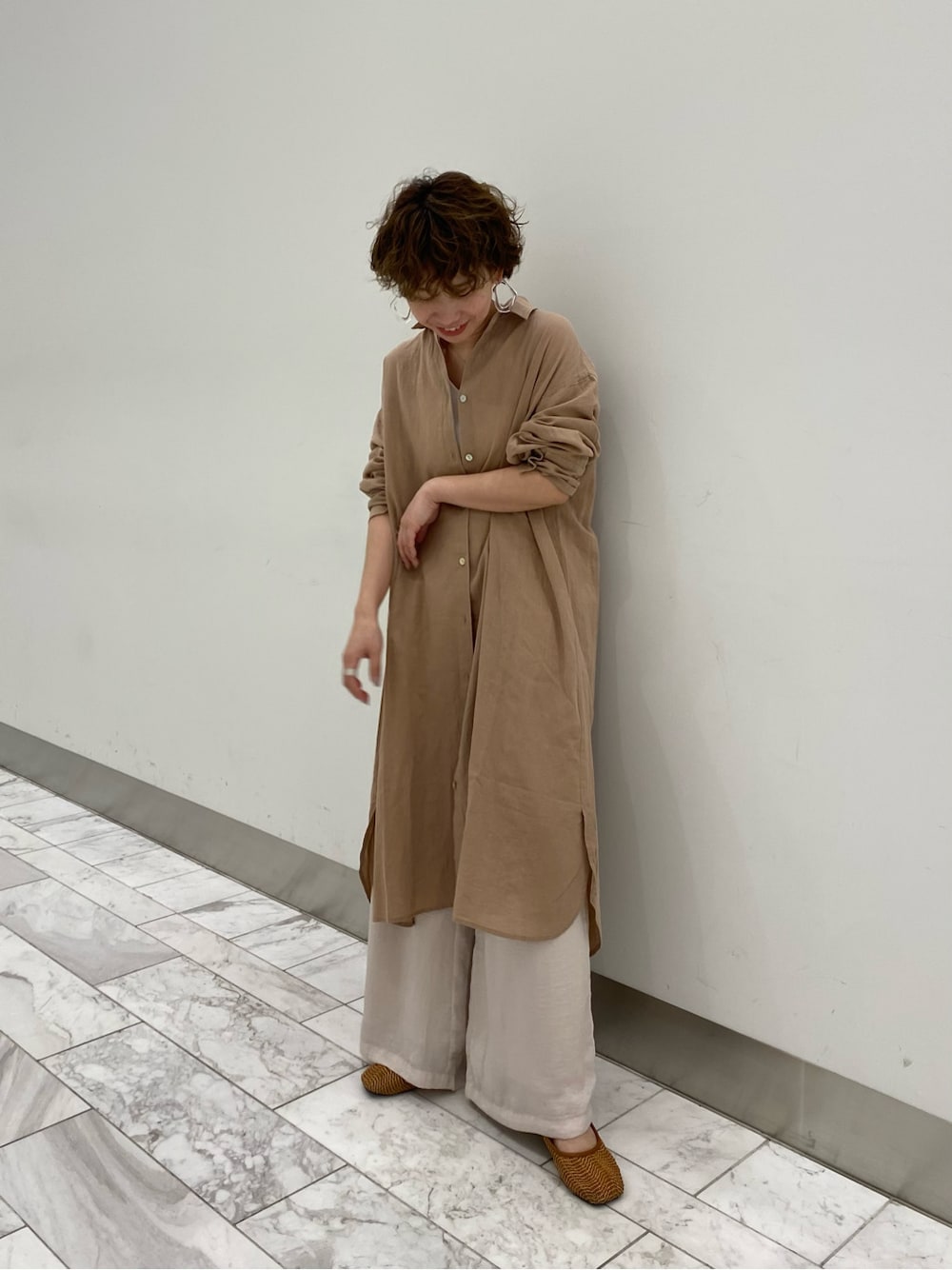 ベージュ系のワンピース、ベージュ系のその他パンツ、ホワイト系のタンクトップを着用したレディースの春コーディネートの2枚目の写真