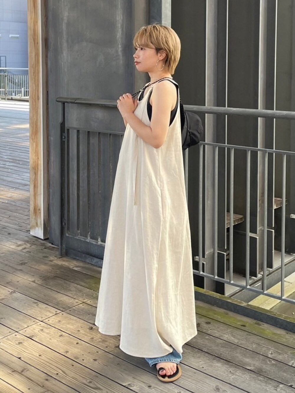 グレー系のTシャツ/カットソー、ブラック系のサンダル、ホワイト系のワンピースを着用したレディースの夏コーディネートの3枚目の写真