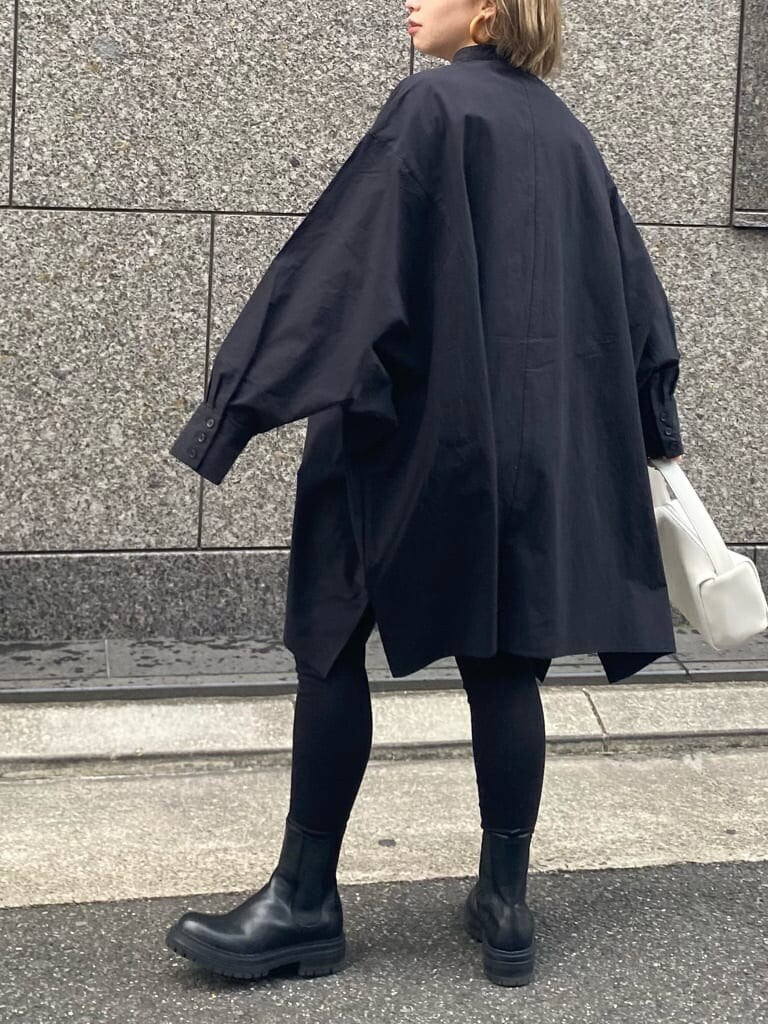 ベージュ系のトレンチコート、ブラック系のシャツ/ブラウス、ホワイト系のハンドバッグを着用したレディースの冬コーディネートの3枚目の写真