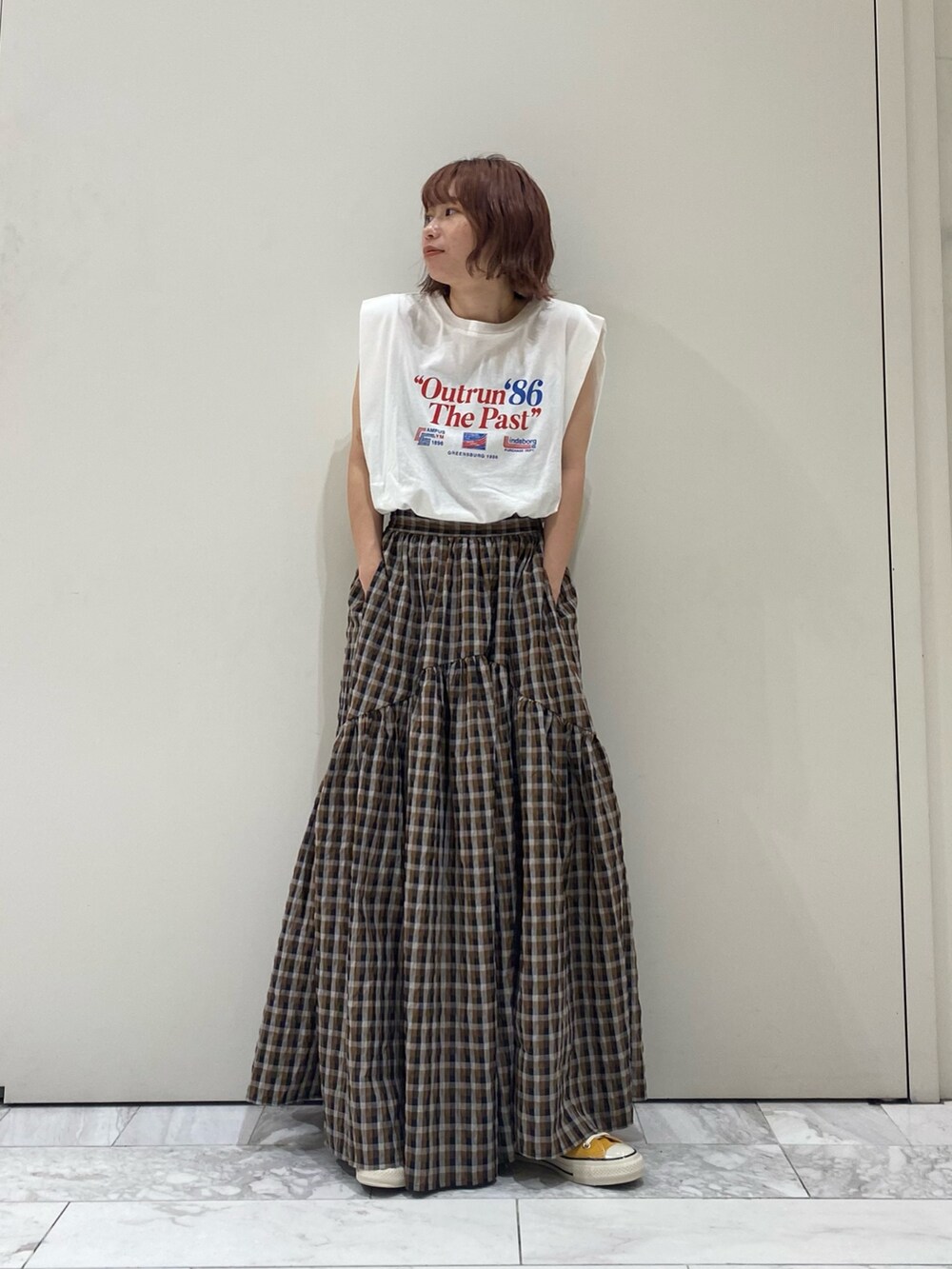ブラウン系のスカート、ホワイト系のタンクトップを着用したレディースの夏コーディネートの2枚目の写真