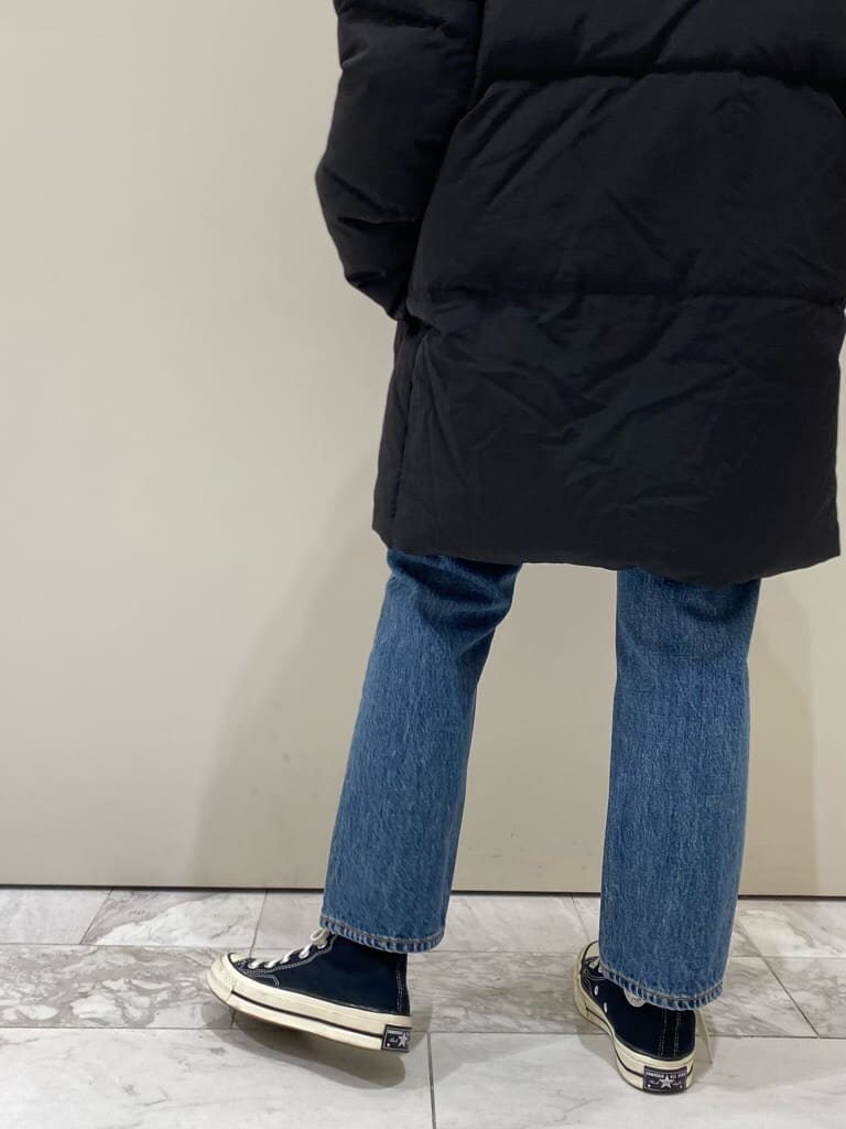 ブラック系のTシャツ/カットソー、ブルー系のデニムパンツ、ブラック系のダウンジャケット/コートを着用したレディースの秋コーディネートの5枚目の写真