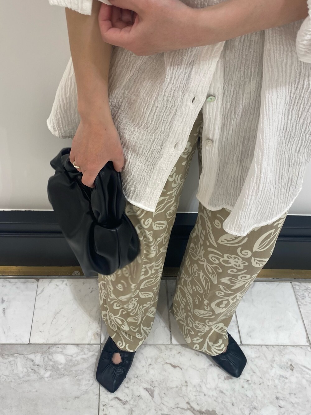 ブラック系のパンプス、ホワイト系のシャツ/ブラウス、ブラック系のハンドバッグを着用したレディースの春コーディネートの5枚目の写真