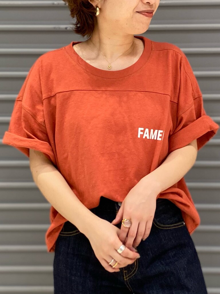 ブルー系のデニムパンツ、オレンジ系のTシャツ/カットソーを着用したレディースの春コーディネートの3枚目の写真
