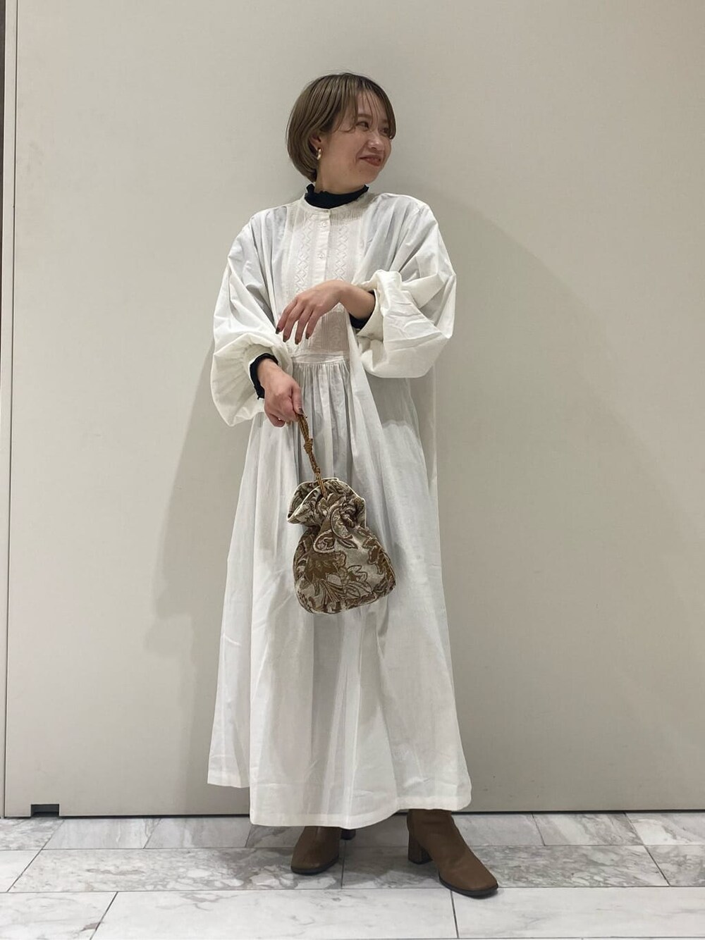 ホワイト系のハンドバッグ、ホワイト系のワンピースを着用したレディースの秋コーディネートの5枚目の写真