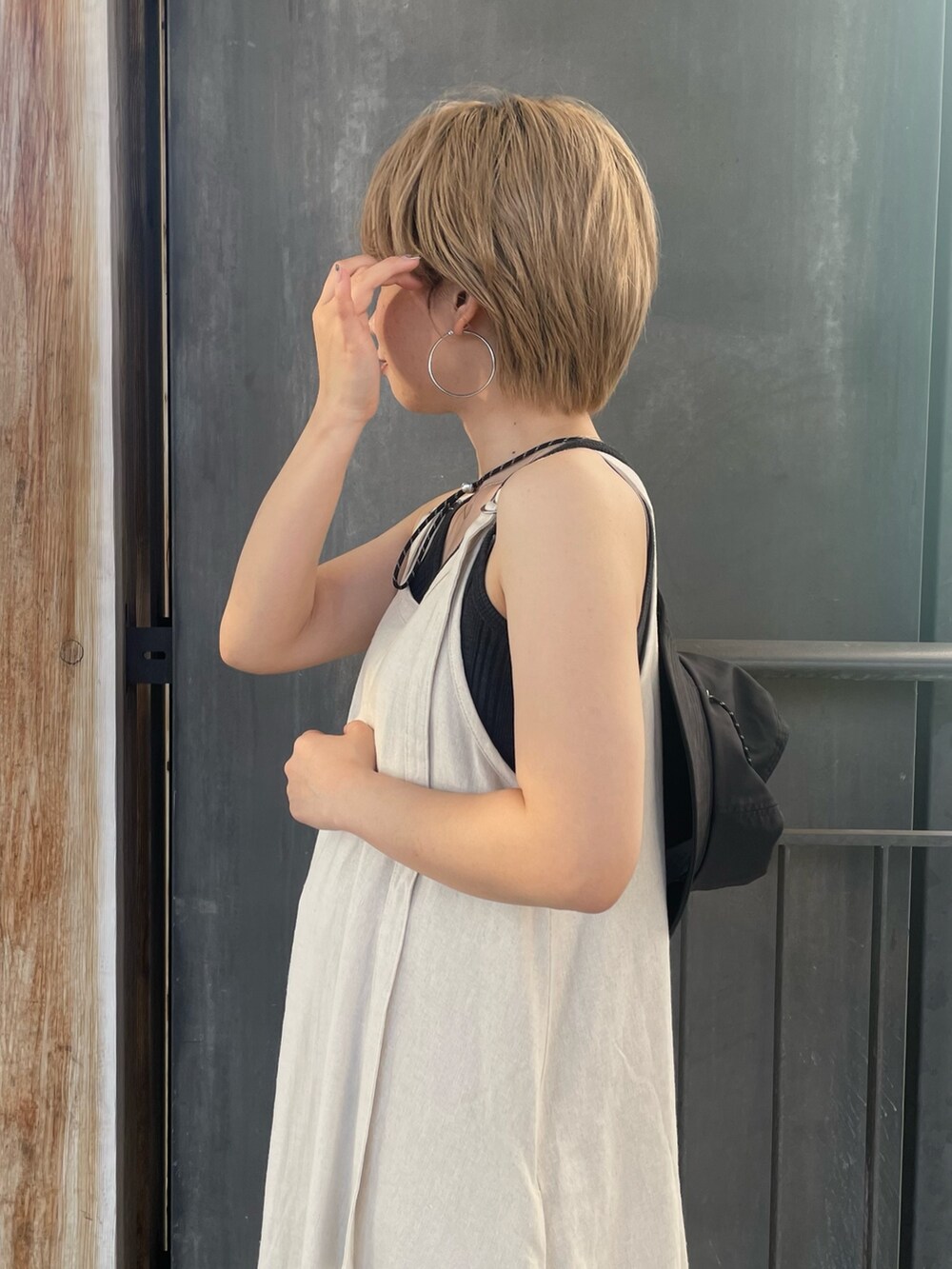 グレー系のTシャツ/カットソー、ブラック系のサンダル、ホワイト系のワンピースを着用したレディースの夏コーディネートの5枚目の写真