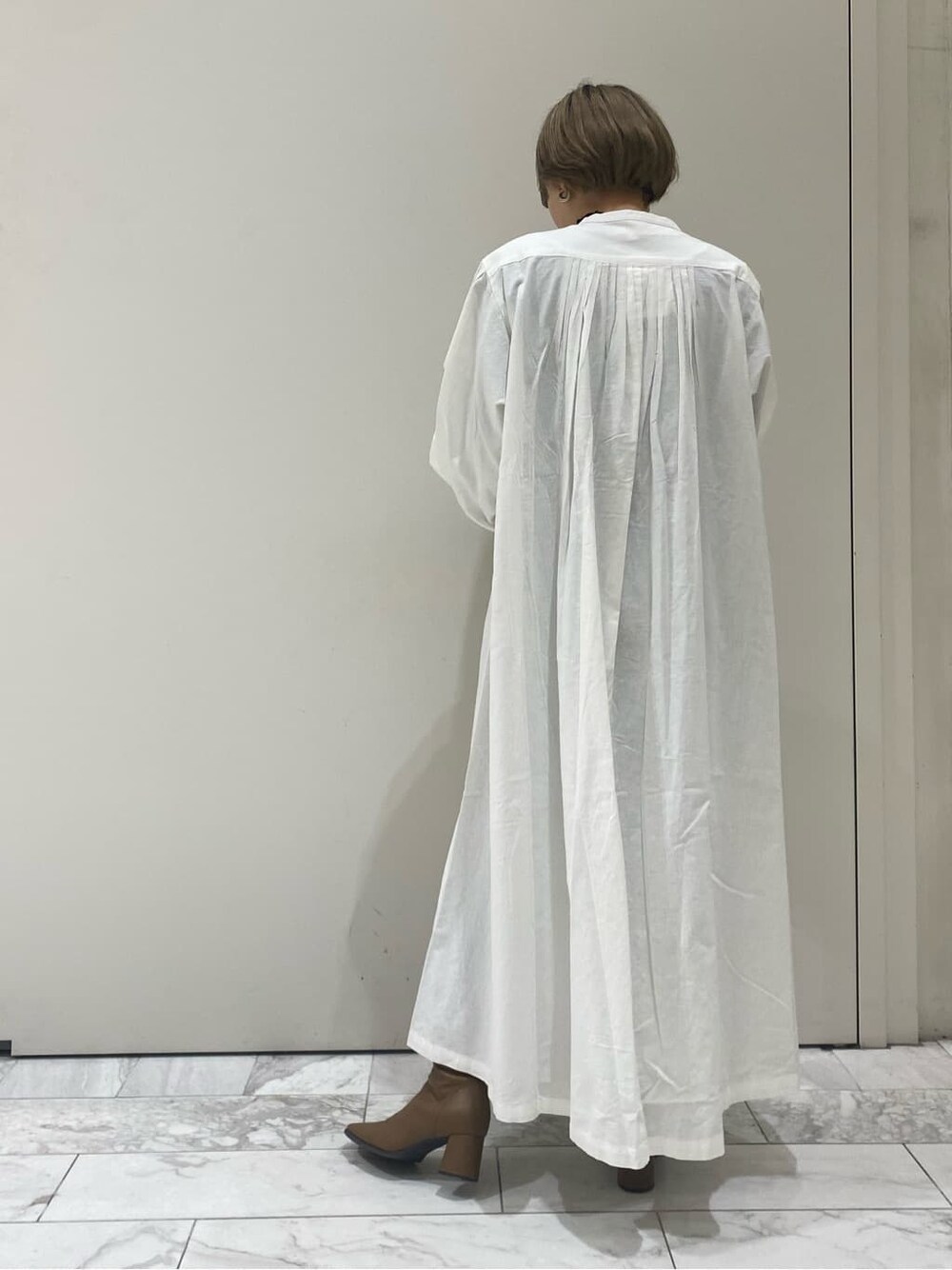 ホワイト系のハンドバッグ、ホワイト系のワンピースを着用したレディースの秋コーディネートの2枚目の写真