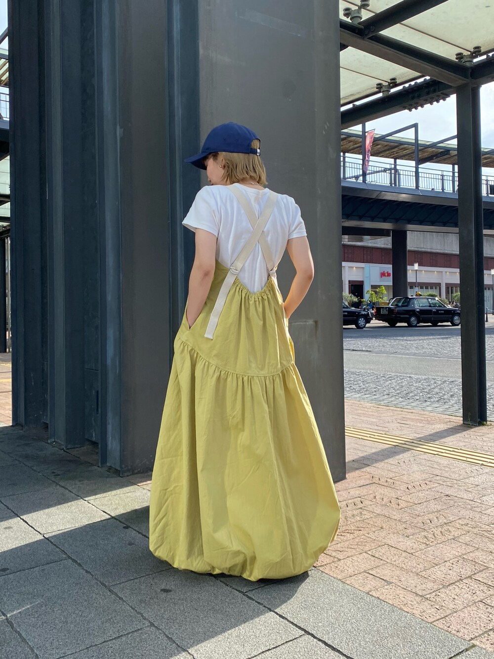 グリーン系のワンピース、ホワイト系のTシャツ/カットソー、ホワイト系のスニーカーを着用したレディースの春コーディネートの3枚目の写真