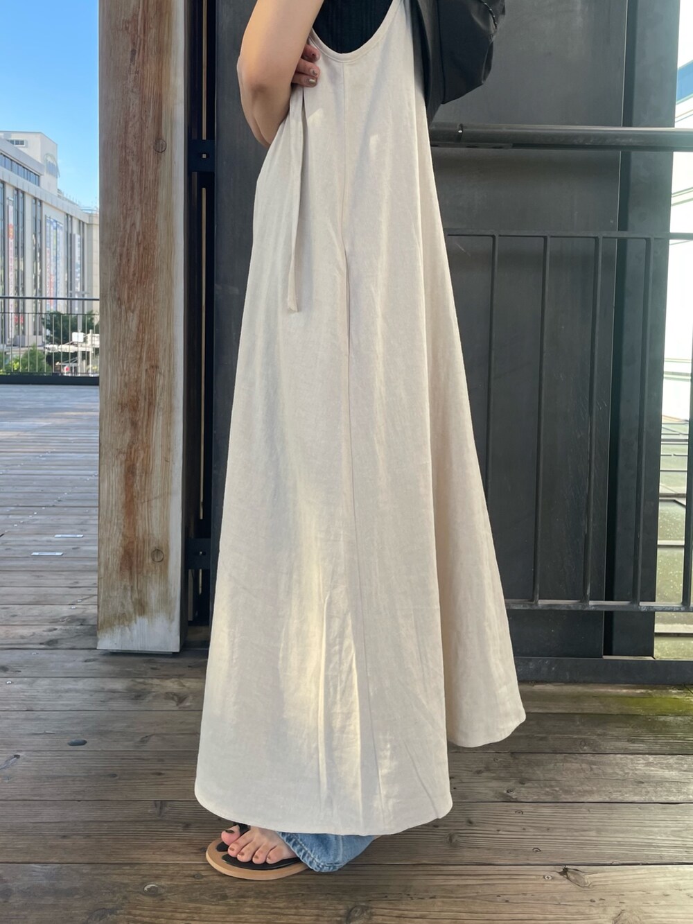 グレー系のTシャツ/カットソー、ブラック系のサンダル、ホワイト系のワンピースを着用したレディースの夏コーディネートの8枚目の写真