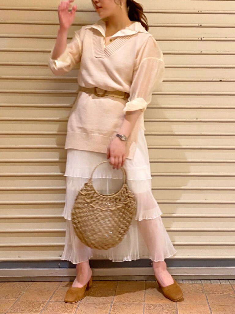 ベージュ系のハンドバッグ、ホワイト系のスカート、ホワイト系のシャツ/ブラウスを着用したレディースの夏コーディネートの2枚目の写真