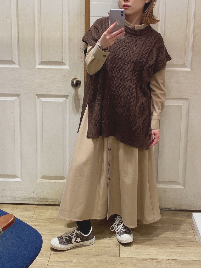 ベージュ系のワンピース、ブラウン系のベストを着用したレディースの冬コーディネートの2枚目の写真