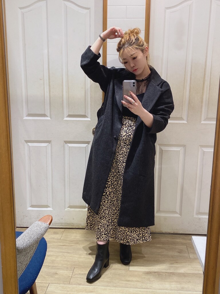 ブラウン系のスカート、ブラック系のブーツ、ブラック系のニット/セーターを着用したレディースの秋コーディネートの2枚目の写真