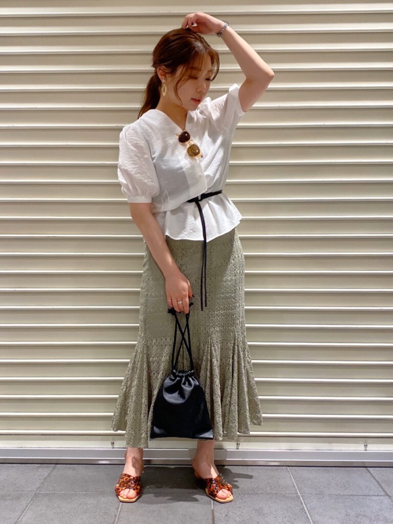 ホワイト系のシャツ/ブラウス、ブラック系のハンドバッグ、その他のサンダルを着用したレディースの夏コーディネートの2枚目の写真