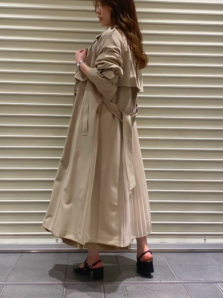 ベージュ系のトレンチコート、ブラック系のパンプス、ベージュ系のワンピースを着用したレディースの夏コーディネートの7枚目の写真