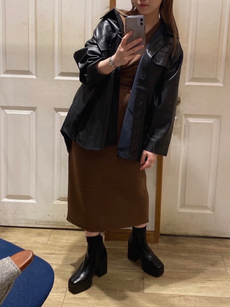 ブラック系のテーラードジャケット、ブラウン系のワンピース、ブラック系のブーツを着用したレディースの秋コーディネートの3枚目の写真