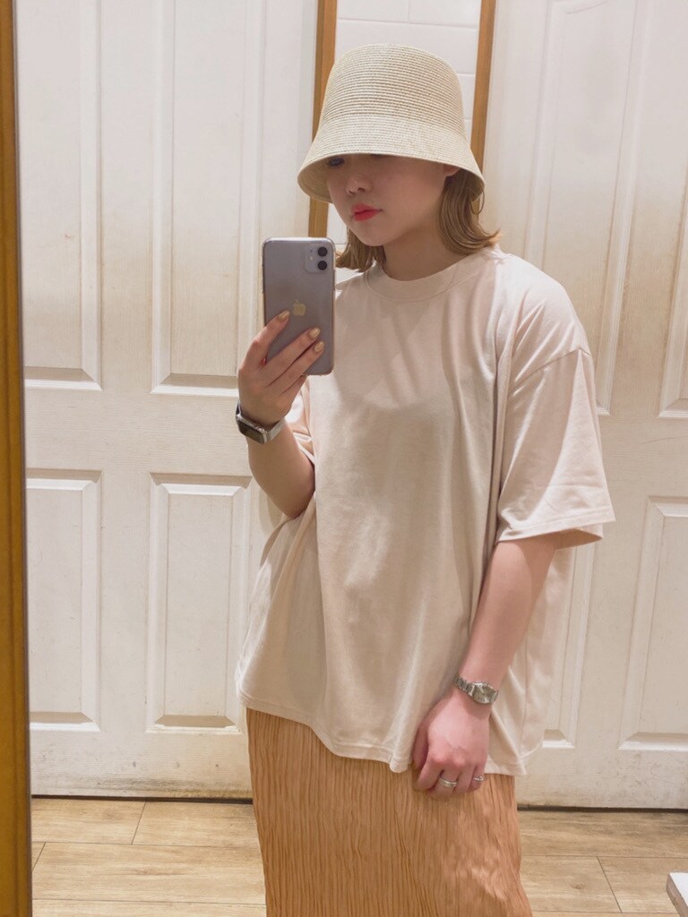 オレンジ系のスカート、オレンジ系のTシャツ/カットソー、ホワイト系のハットを着用したレディースの春コーディネートの3枚目の写真