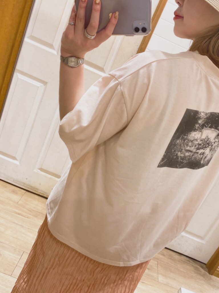 オレンジ系のスカート、オレンジ系のTシャツ/カットソー、ホワイト系のハットを着用したレディースの春コーディネートの2枚目の写真