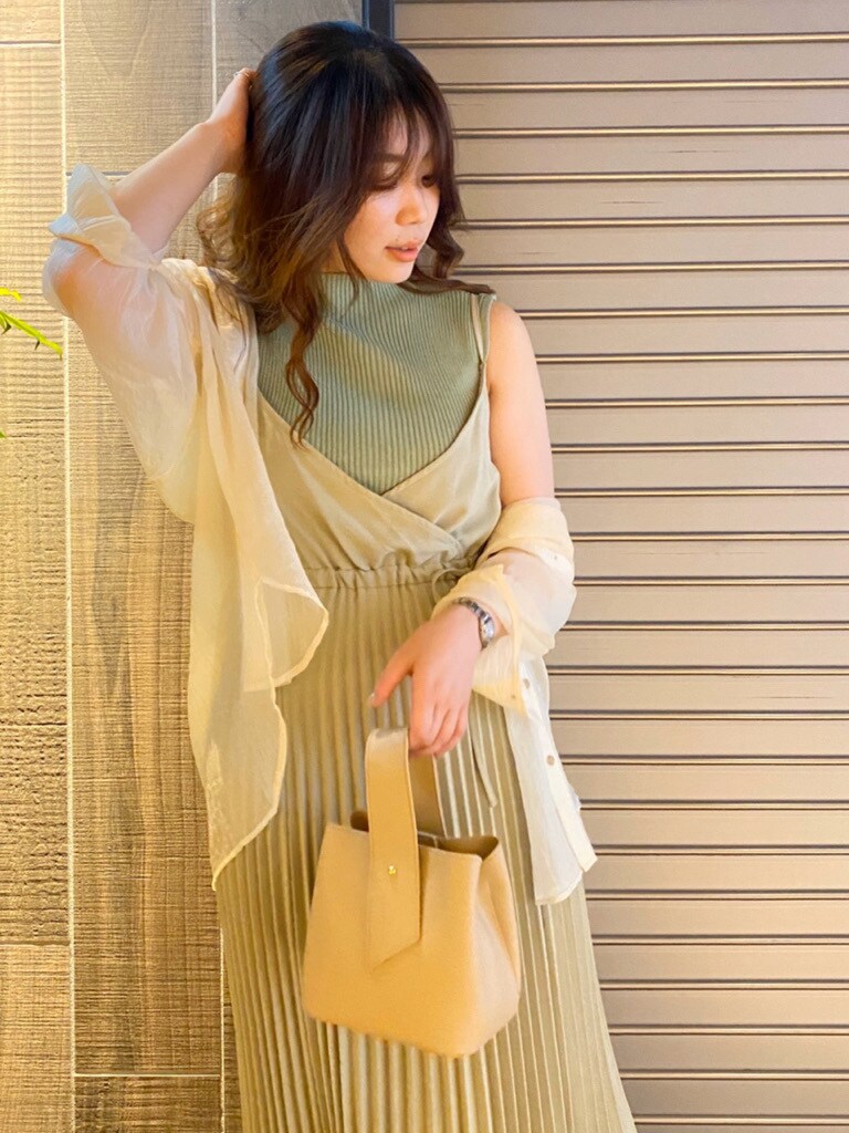 ベージュ系のワンピース、グリーン系のニット/セーター、ホワイト系のハンドバッグを着用したレディースの春コーディネートの5枚目の写真