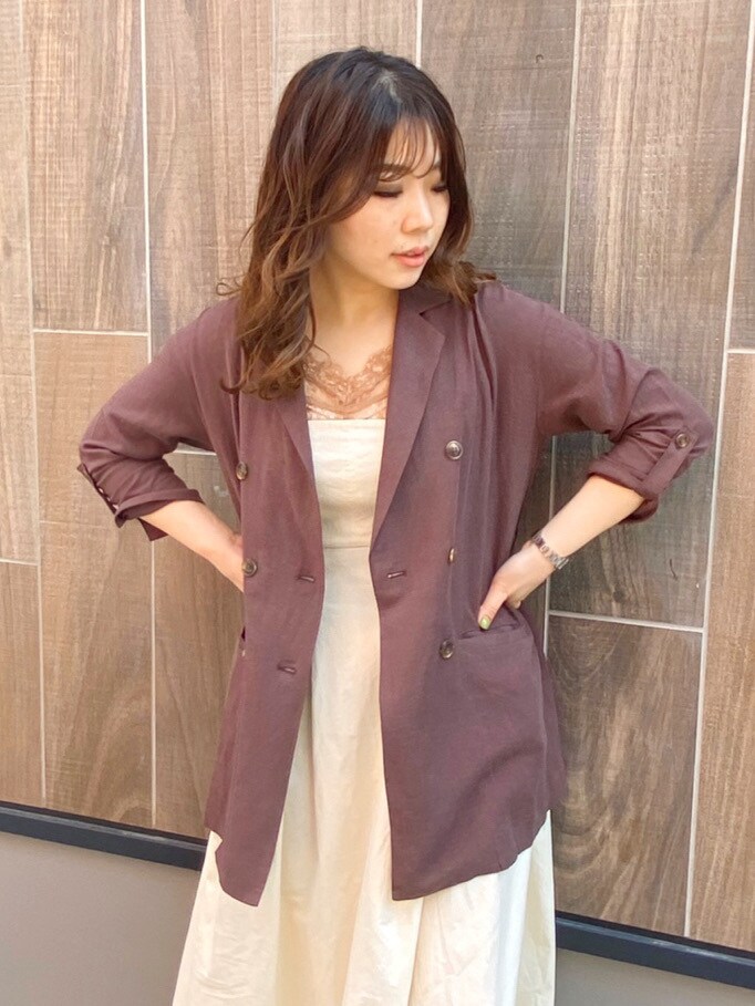 ブラウン系のテーラードジャケット、ホワイト系のワンピース、ホワイト系のパンプスを着用したレディースの春コーディネートの2枚目の写真