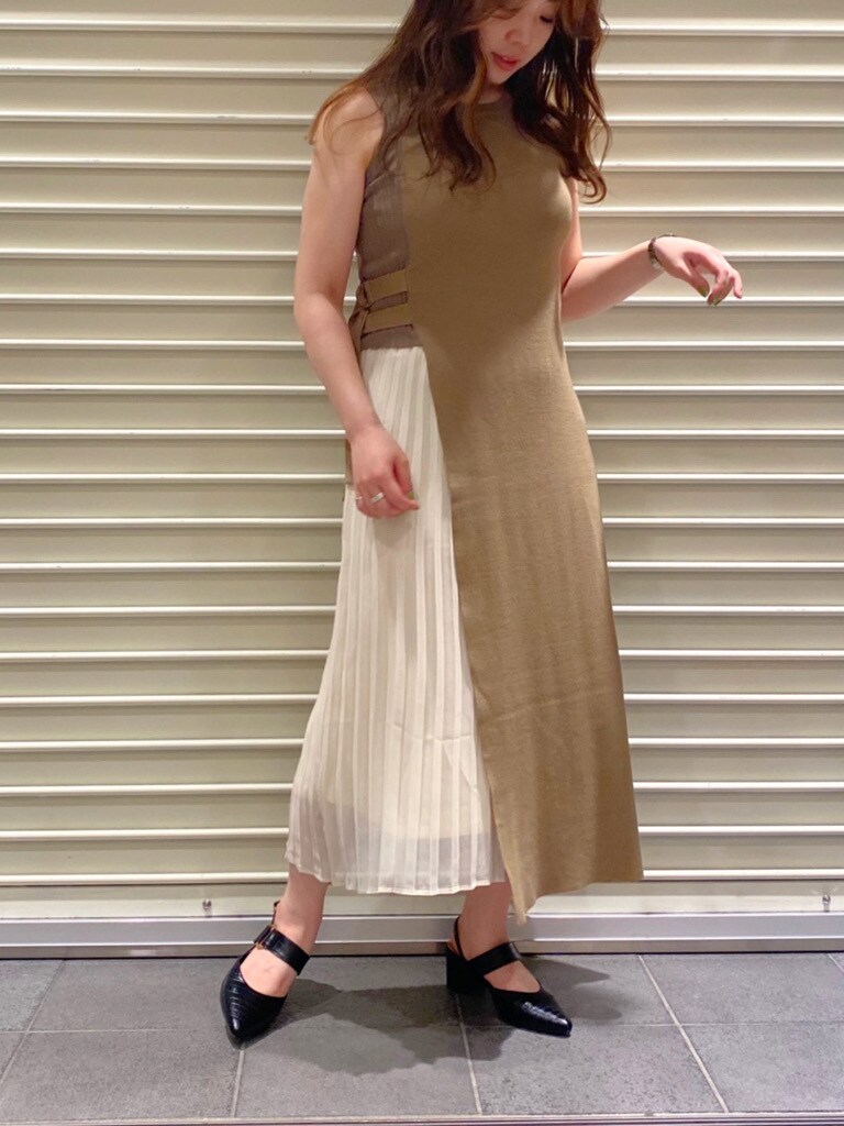 ベージュ系のトレンチコート、ブラック系のパンプス、ベージュ系のワンピースを着用したレディースの夏コーディネートの3枚目の写真