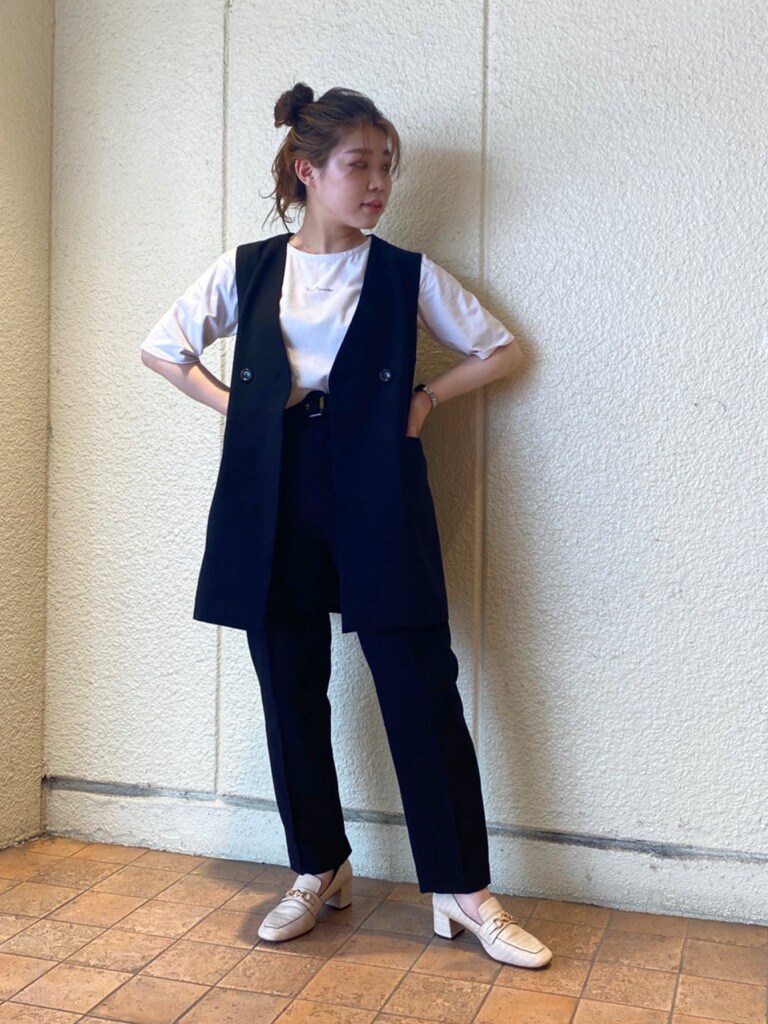 ブラック系のテーラードジャケット、ブラック系のベスト、ホワイト系のローファーを着用したレディースの夏コーディネートの4枚目の写真