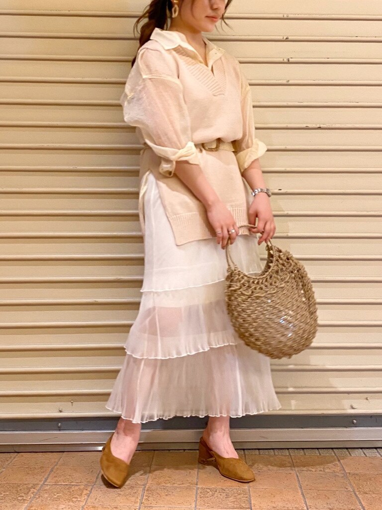 ベージュ系のハンドバッグ、ホワイト系のスカート、ホワイト系のシャツ/ブラウスを着用したレディースの夏コーディネートの3枚目の写真