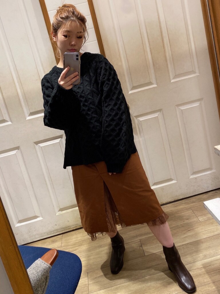 ブラウン系のスカート、ブラウン系のブーツ、ブラック系のニット/セーターを着用したレディースの秋コーディネートの3枚目の写真