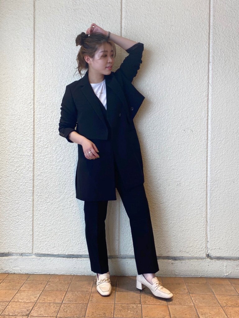 ブラック系のテーラードジャケット、ブラック系のベスト、ホワイト系のローファーを着用したレディースの夏コーディネートの2枚目の写真