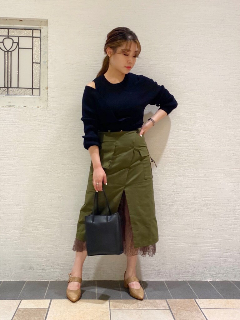 ベージュ系のパンプス、ブラック系のニット/セーター、グリーン系のスカートを着用したレディースの夏コーディネートの2枚目の写真