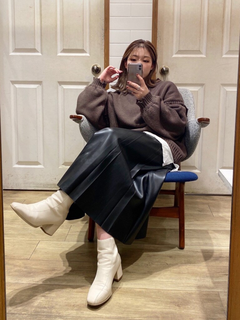ホワイト系のブーツ、ブラウン系のニット/セーター、ブラック系のスカートを着用したレディースの秋コーディネートの4枚目の写真