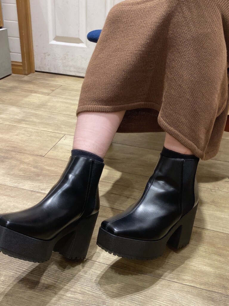 ブラック系のテーラードジャケット、ブラウン系のワンピース、ブラック系のブーツを着用したレディースの秋コーディネートの9枚目の写真