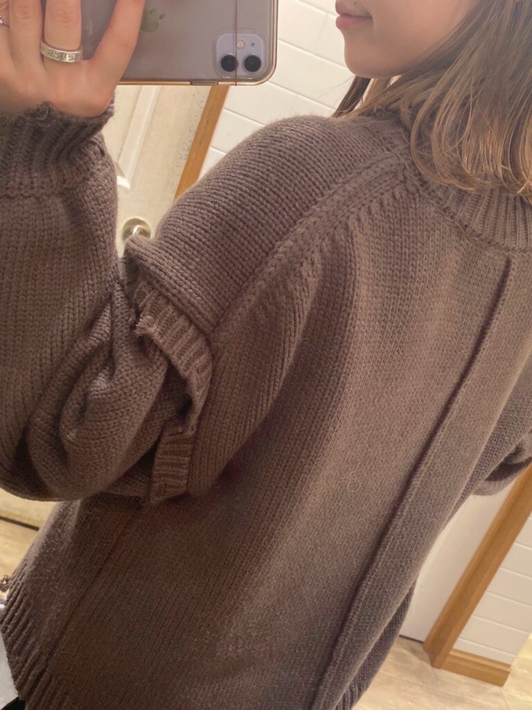 ホワイト系のブーツ、ブラウン系のニット/セーター、ブラック系のスカートを着用したレディースの秋コーディネートの3枚目の写真