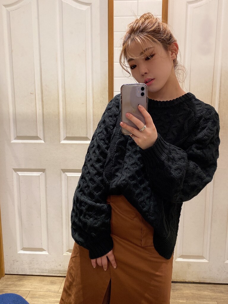 ブラウン系のスカート、ブラウン系のブーツ、ブラック系のニット/セーターを着用したレディースの秋コーディネートの5枚目の写真