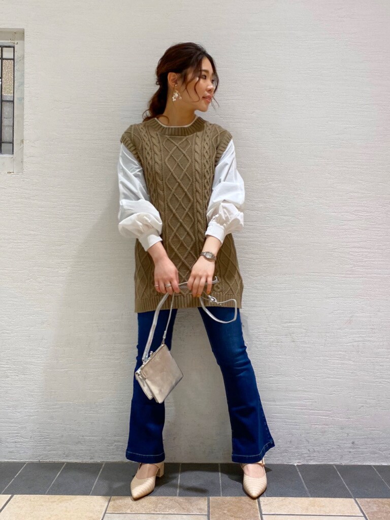 ブルー系のデニムパンツ、ホワイト系のパンプス、シルバー系のショルダーバッグを着用したレディースの春コーディネートの3枚目の写真