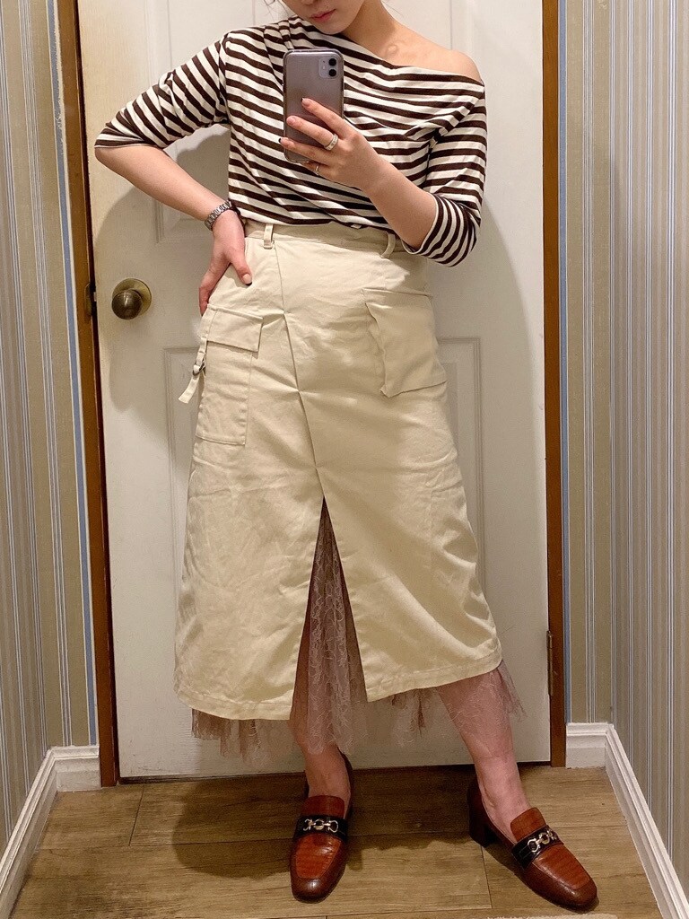 ベージュ系のスカート、ブラウン系のローファーを着用したレディースの秋コーディネートの2枚目の写真