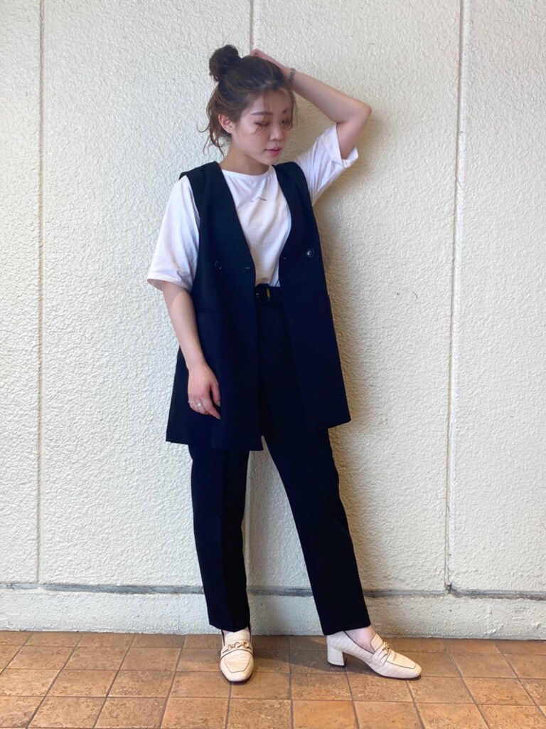 ブラック系のテーラードジャケット、ブラック系のベスト、ホワイト系のローファーを着用したレディースの夏コーディネートの5枚目の写真